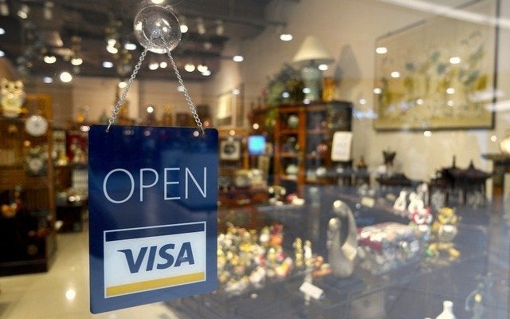 Open sign with the VISA logo in the store window of a home furnishings store