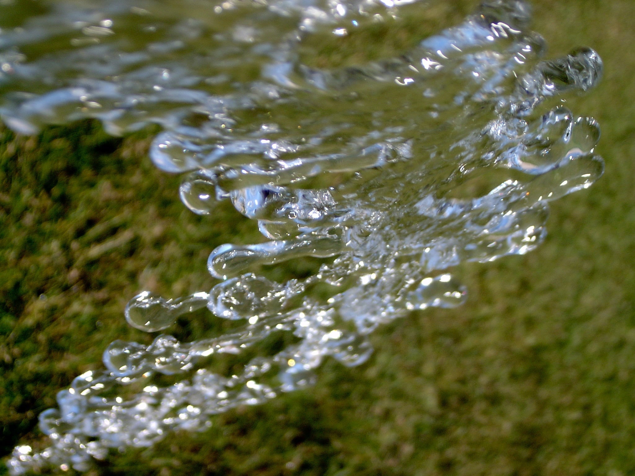 Water particles breaking from garden hose