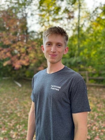 student standing in front of leaves