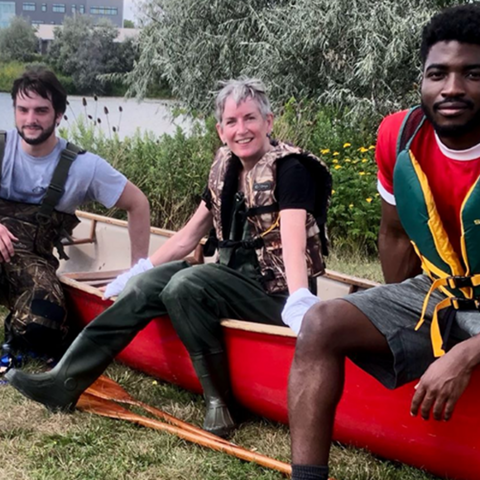 3 students sitting on canoe