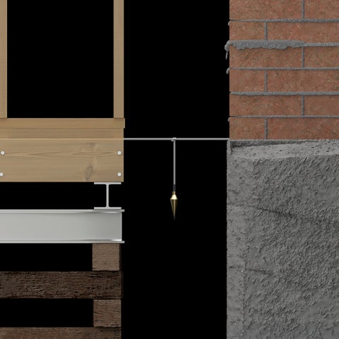 A dowsing pendulum is strung between a wooden structure and a brick foundation