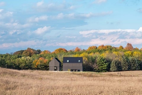 The home is composed of two main sculptural volumes nestled into the surrounding wheat fields. 