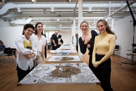 A group of students posing with an architectural model