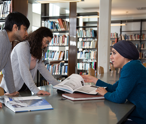 Professor Anwar Jaber working with students in a library
