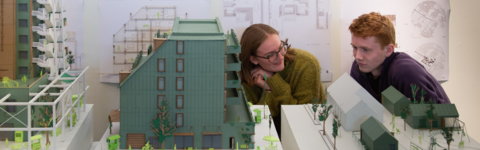 two students discuss an architectural model
