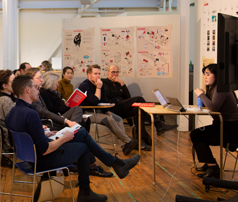 a student defends their architecture thesis in front of a seated audience