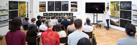 a student defends their architecture thesis in front of a seated audience