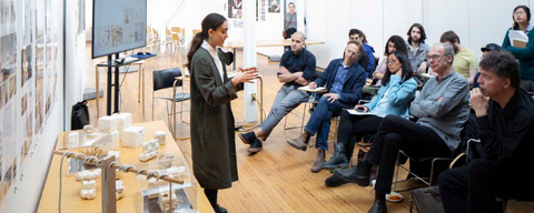 Woman presenting thesis with abstract models and drawings