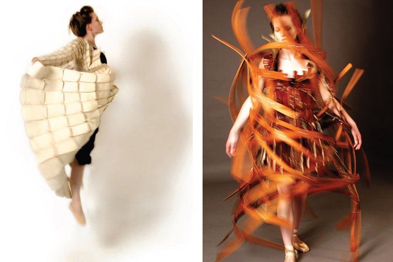 A photograph of a female model wearing a dress made of wood in motion.