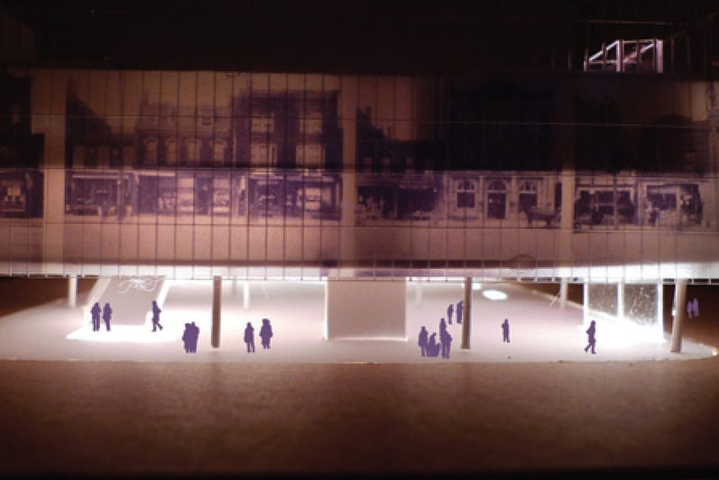 A physical model of a large urban building, it is lit with LED lights from the interior.