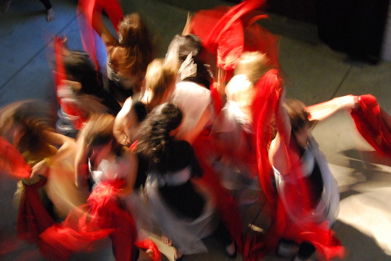 A photograph of people dressed in white and red in motion.