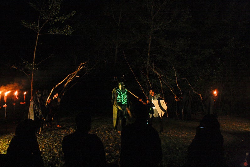 A night time photo of two actors in sword play.