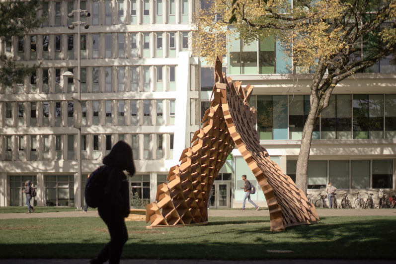 A silhouetted woman looks at an architectural art installation