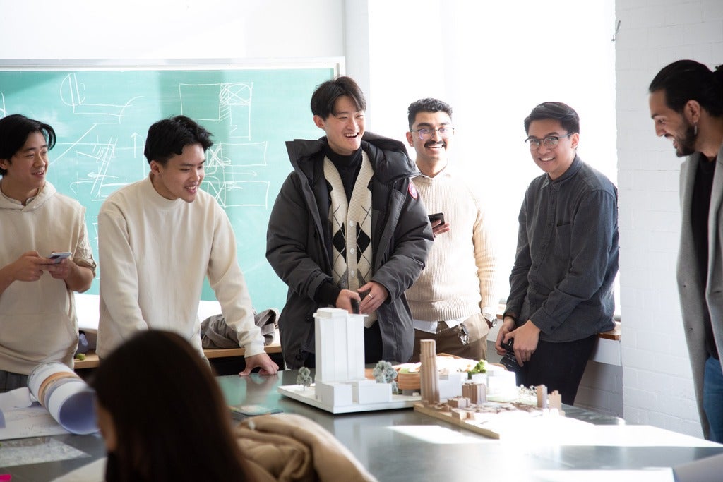 students posing with an architectural model