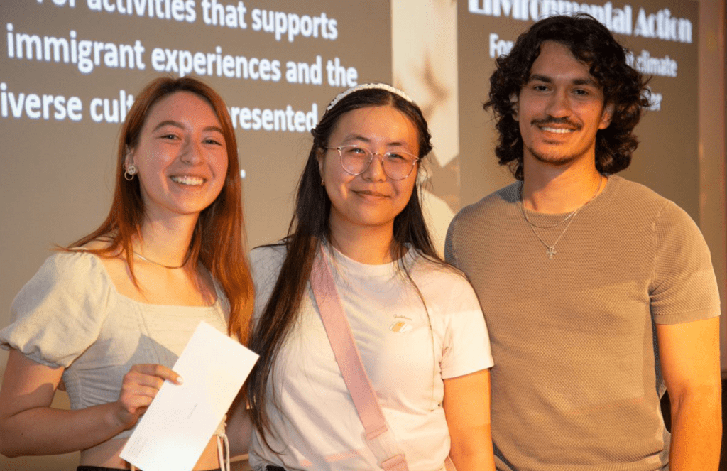 three students posing after being presented with academic awards