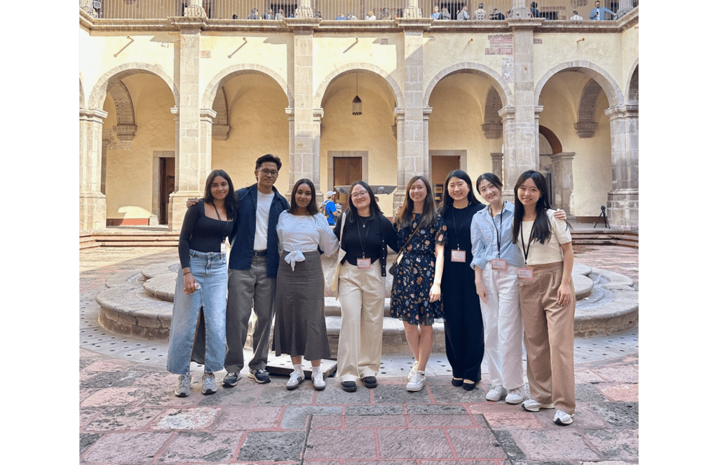 A group of eight students pose in a public square in Mexico