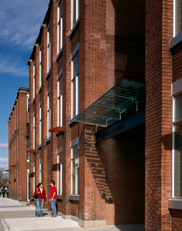 Two students are talking at the front door of the Architecture building