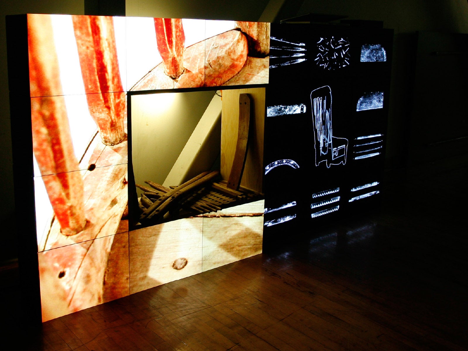 A photograph of some sort of interactive screen constructed with an array of display panels, displaying several abstract forms.