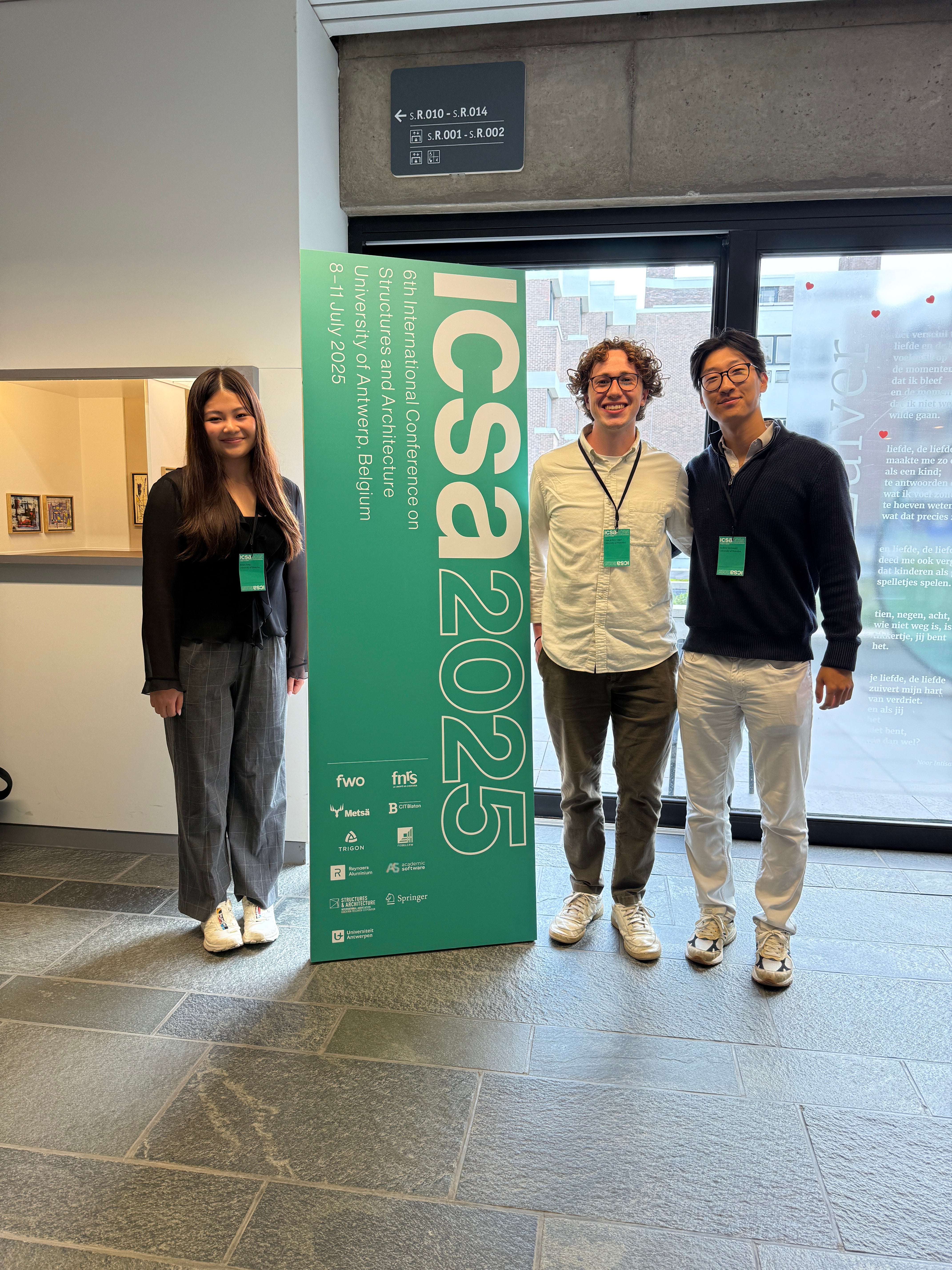 three students pose with the icsa conference banner