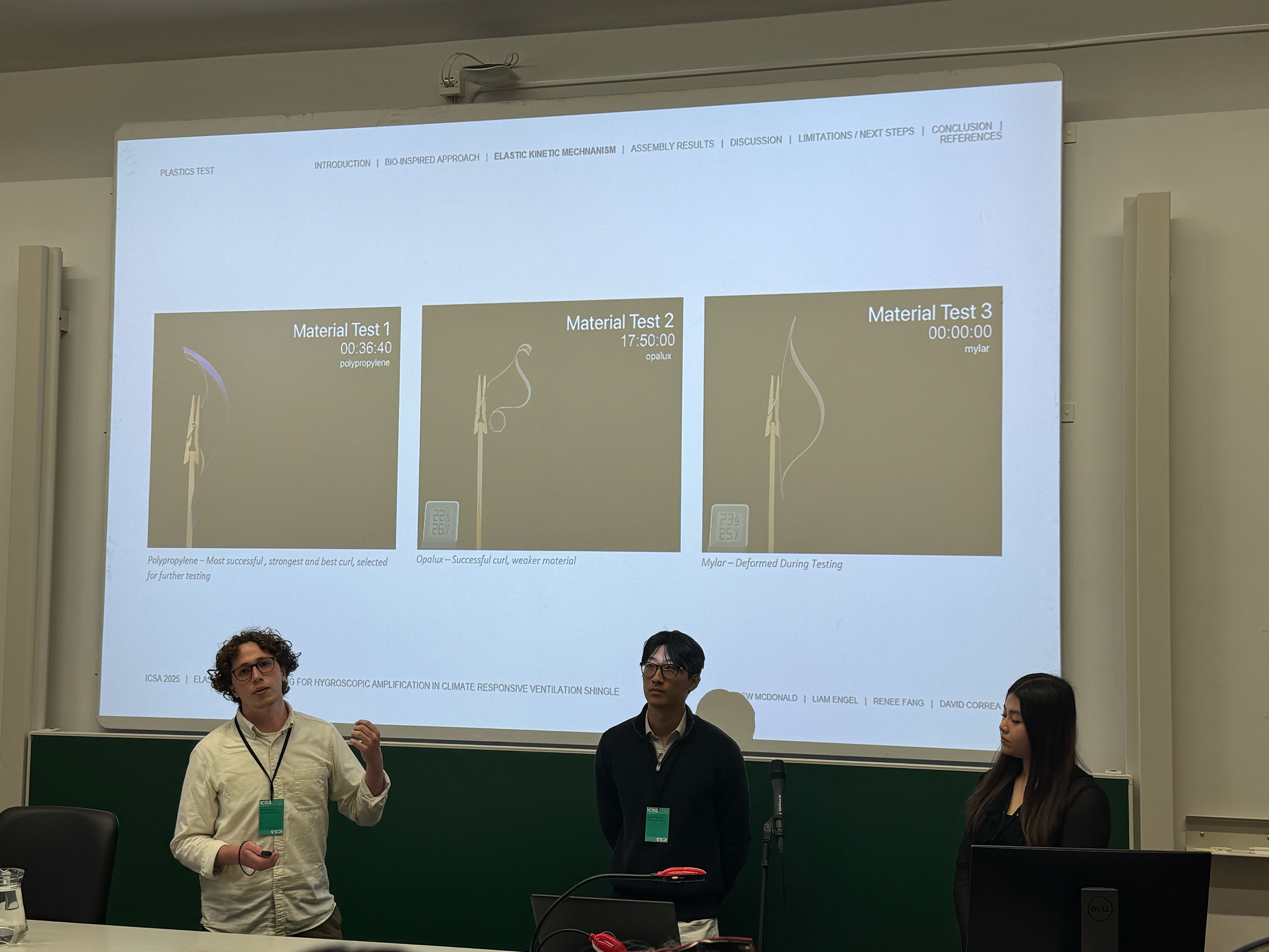 three students present research in a small lecture hall