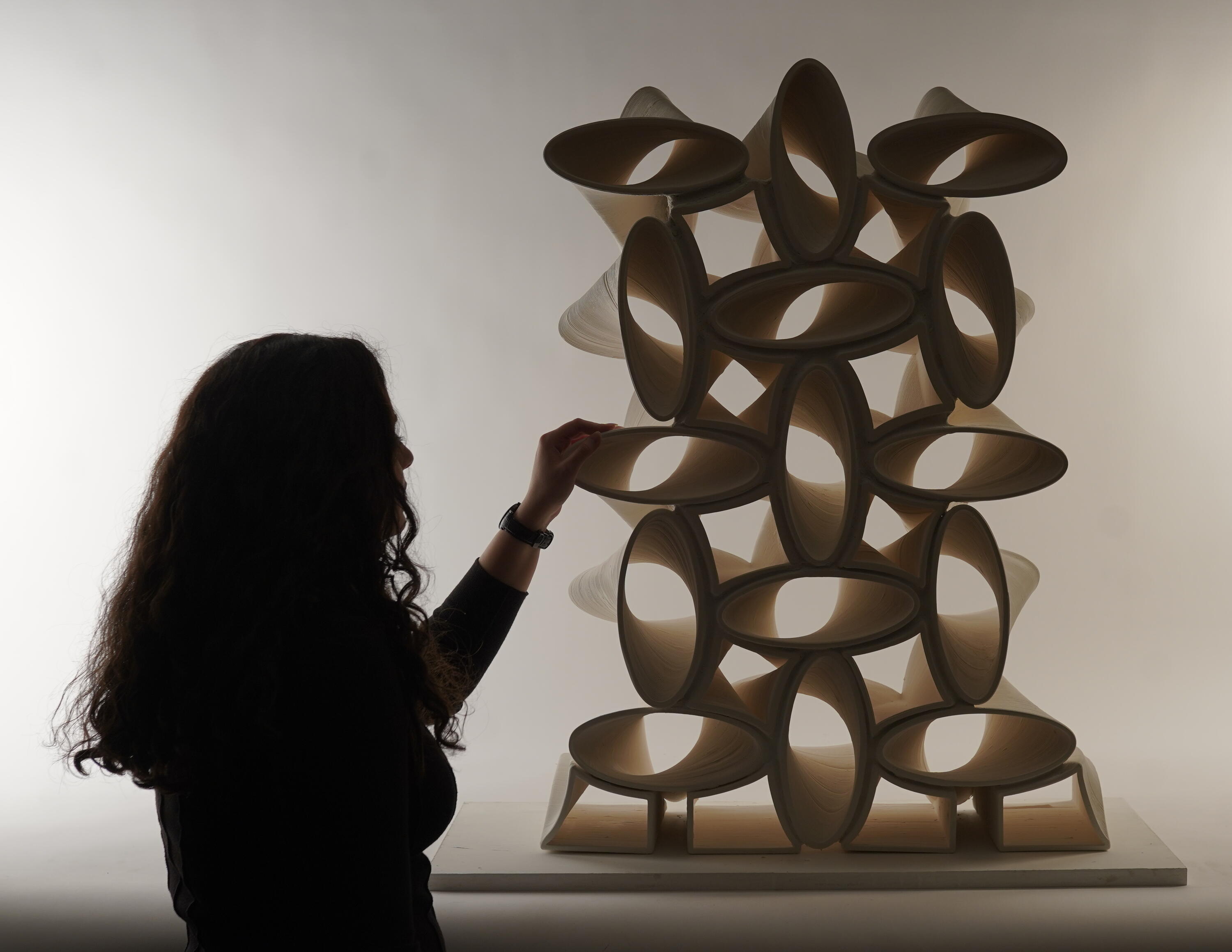 silhouette of a woman looking at a 3d printed sculptural structure