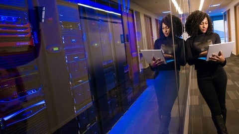 women standing in data room with a laptop