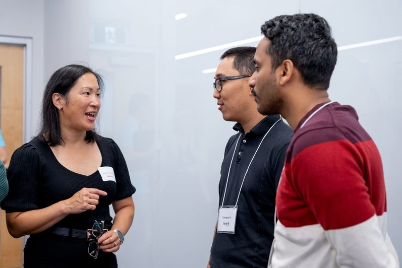 Three attendees chat during the networking portion of the TD Layer 6 visit