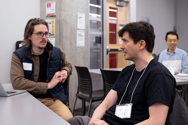 Two attendees in conversation at a table during the TD Layer 6 visit
