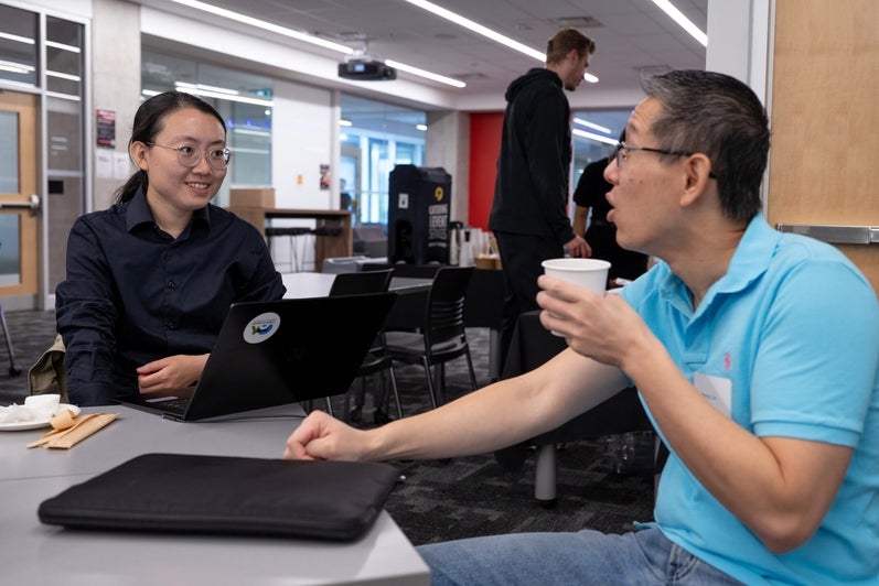 Two attendees talk over coffee during the TD Layer 6 visit