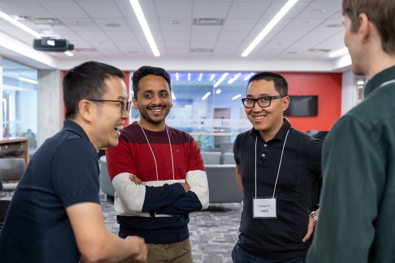 A group of attendees laugh together while networking