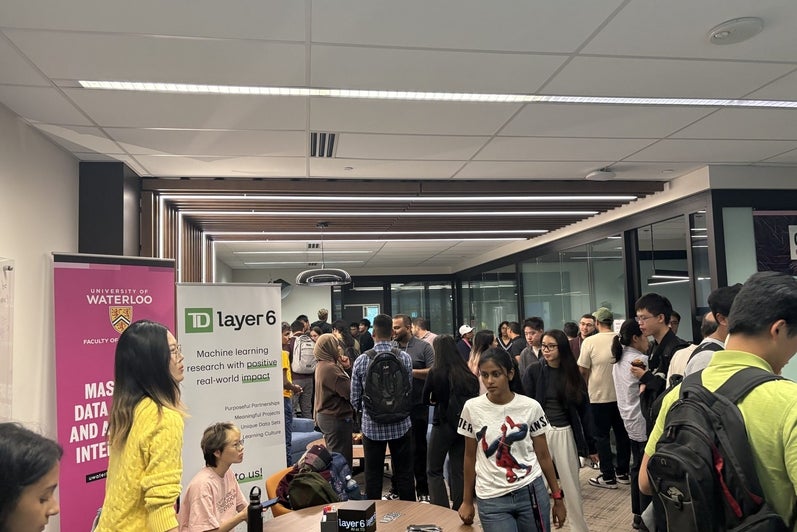 A crowd of students gathers to meet the TD Layer 6 team during the coffee hour