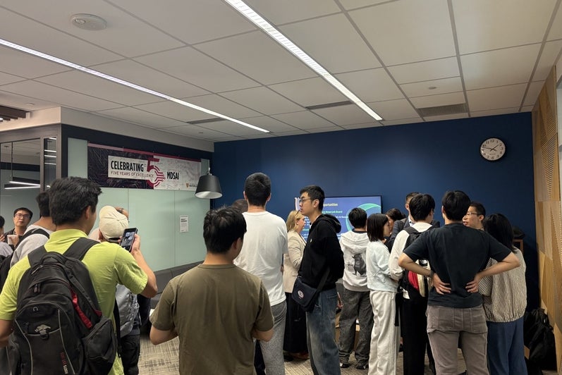 Students line up to talk with TD Layer 6 researchers during the coffee hour