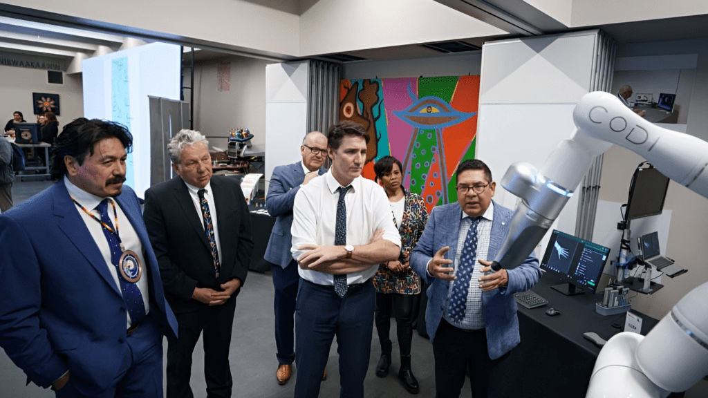 Prime Minister Trudeau, Minister Ien and Minister Vandal look at Cobionix's robot Codi at the Saskatchewan Indian Institute of Technologies in Saskatoon.