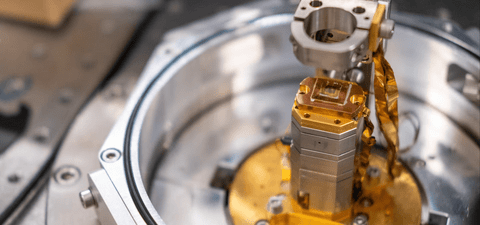 Close-up of a precision scientific instrument with metallic and gold-colored components inside a circular housing.