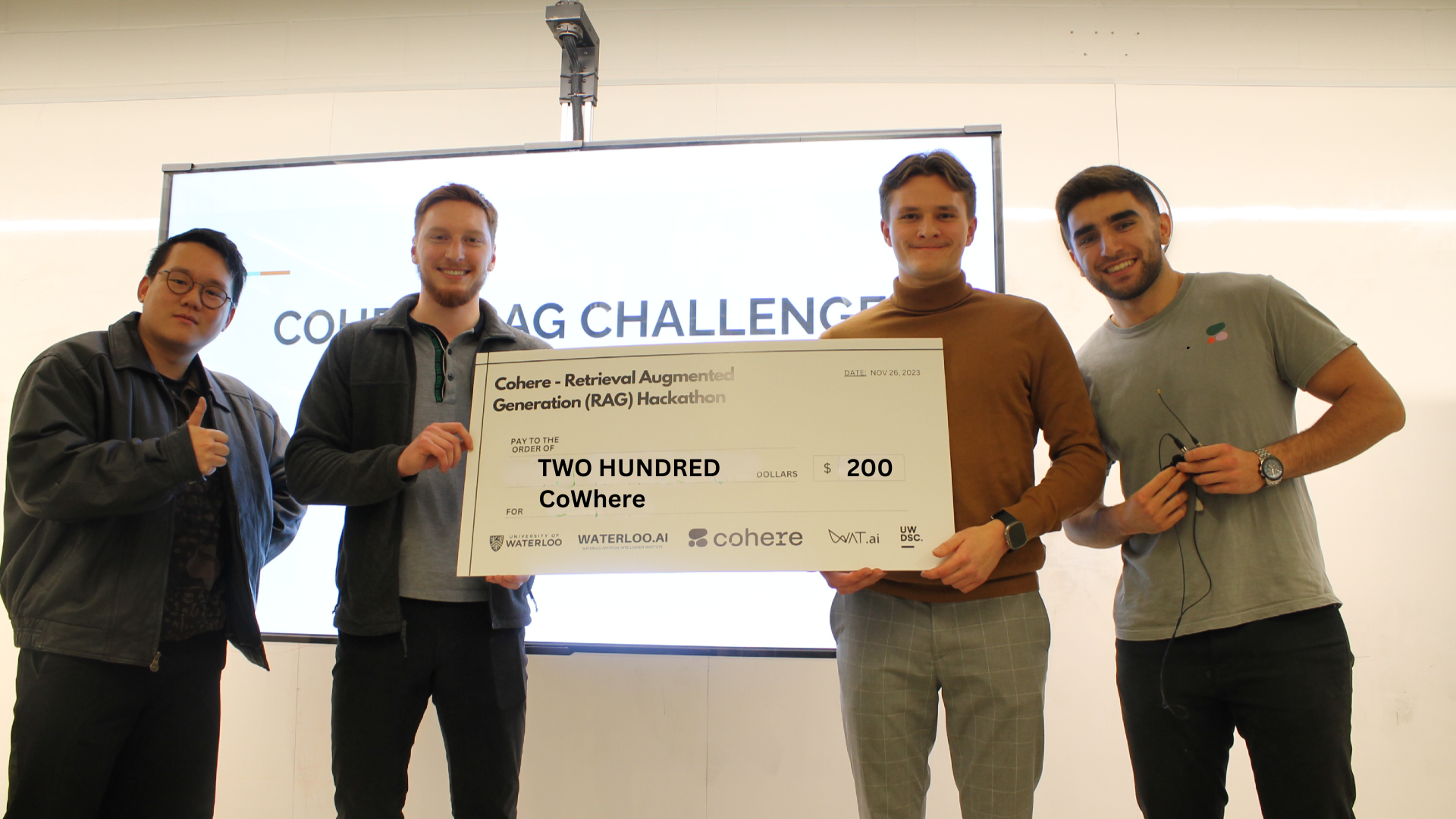 The CoWhere team (L-R: Marko Renic and Michael Solodko) holding a $200 cheque, flanked by Ivan Zhang and Faraz Khoubsirat
