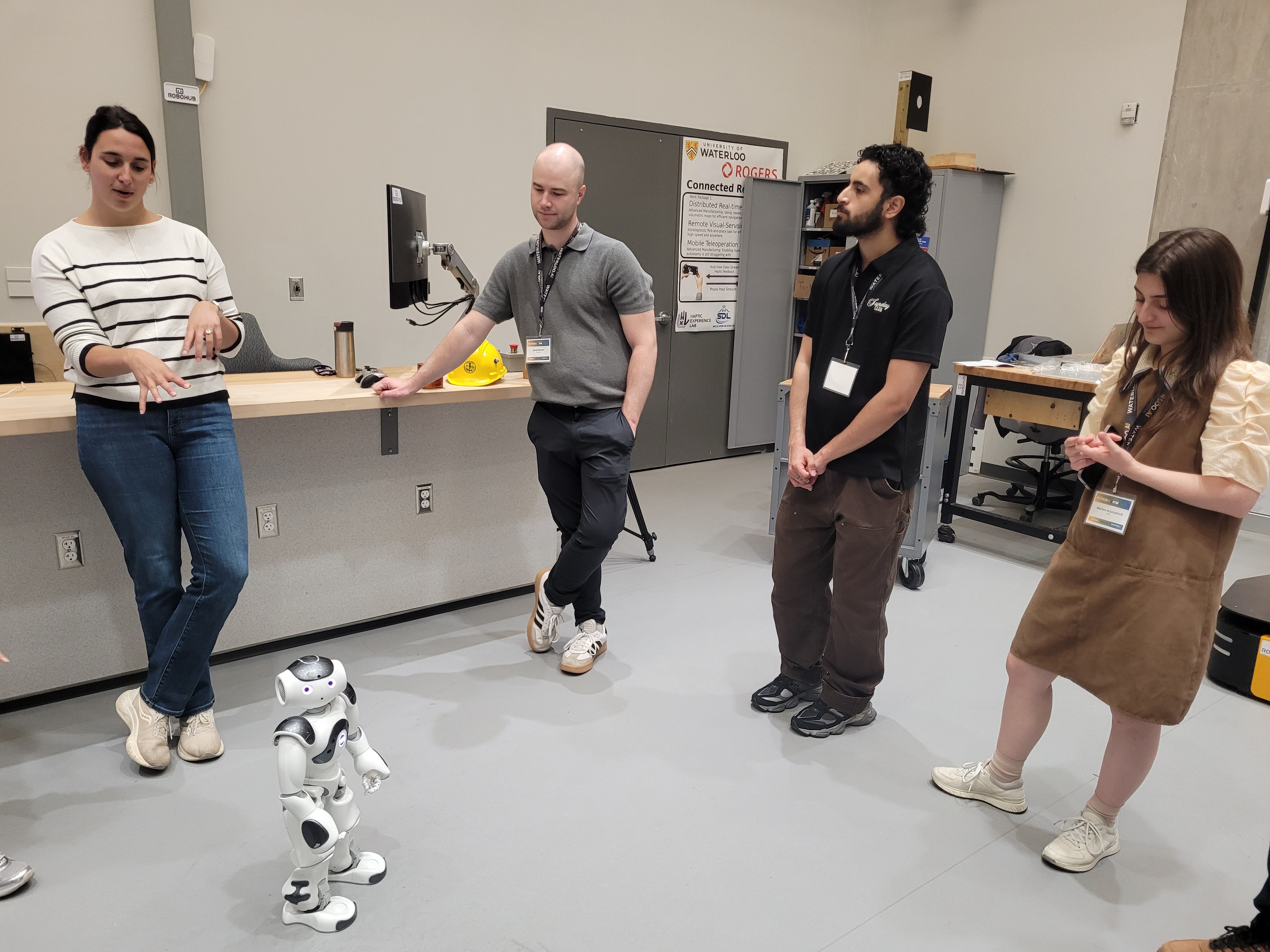 NTNU delegates and Waterloo hosts gather around a NAO robot demonstration at RoboHub, May 2026.
