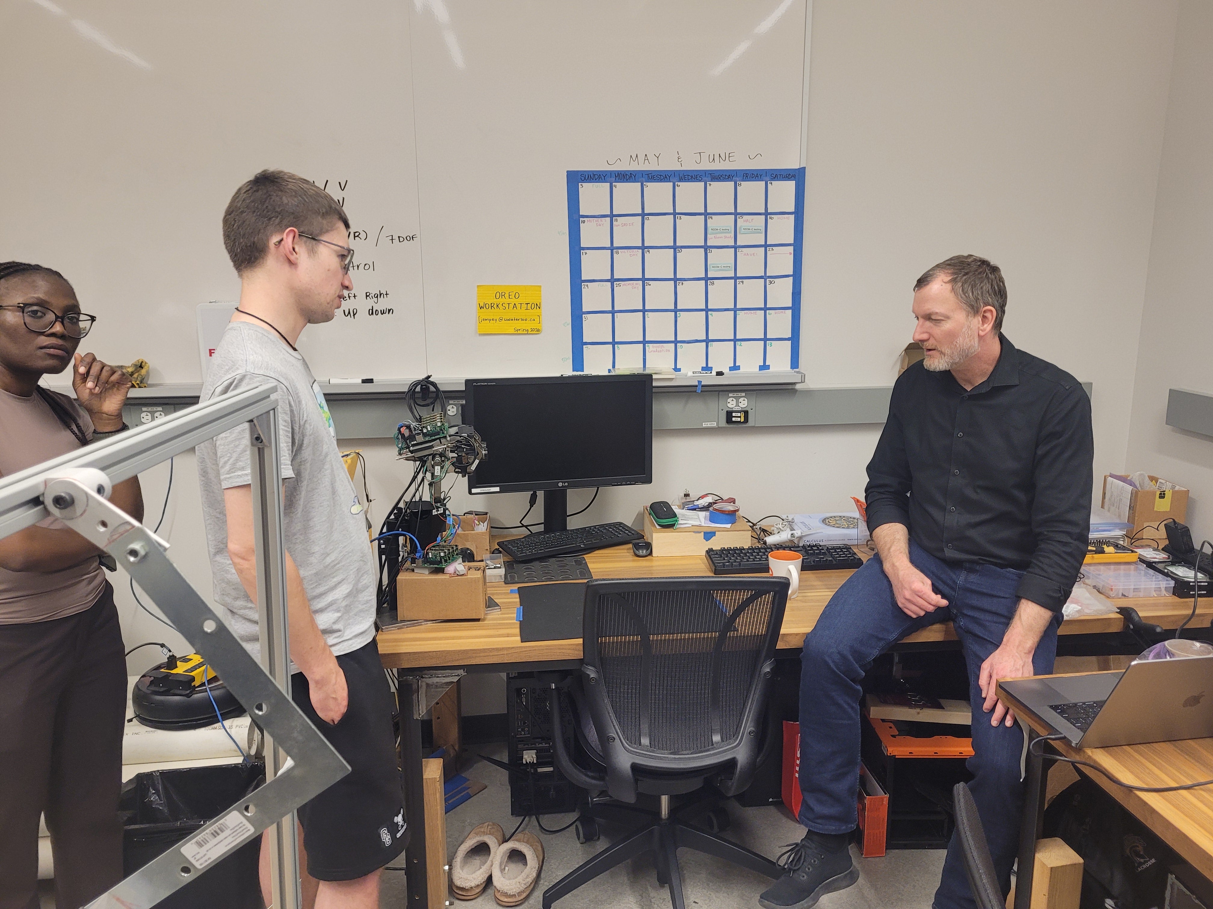 Delegates and researchers watch a robotic-arm demonstration during a talk on deep networks as brain models.