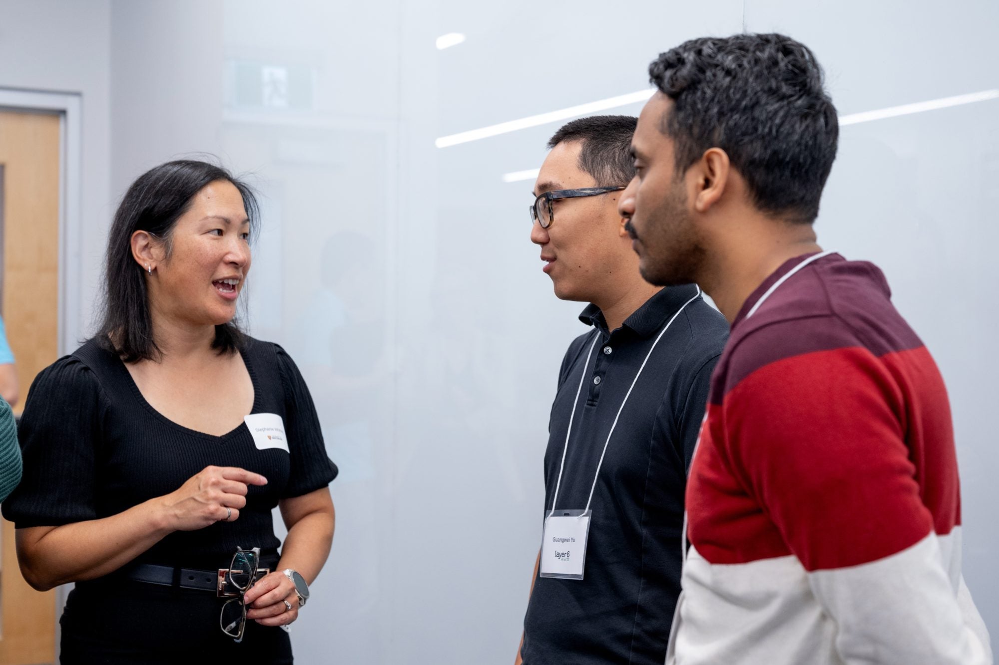 Three attendees chat during the networking portion of the TD Layer 6 visit
