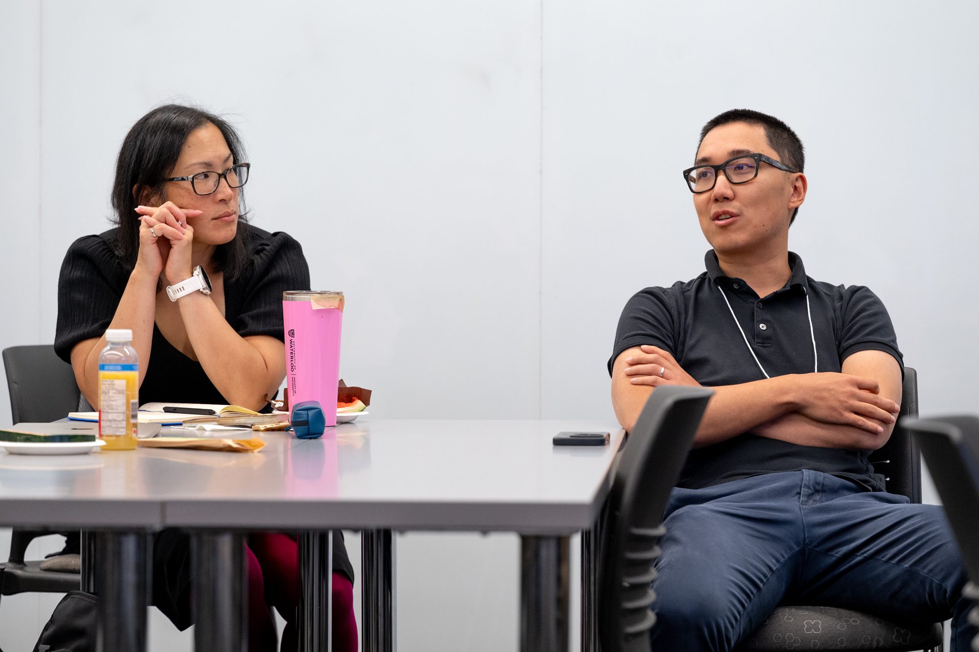 Two attendees seated at a table listen during the TD Layer 6 visit