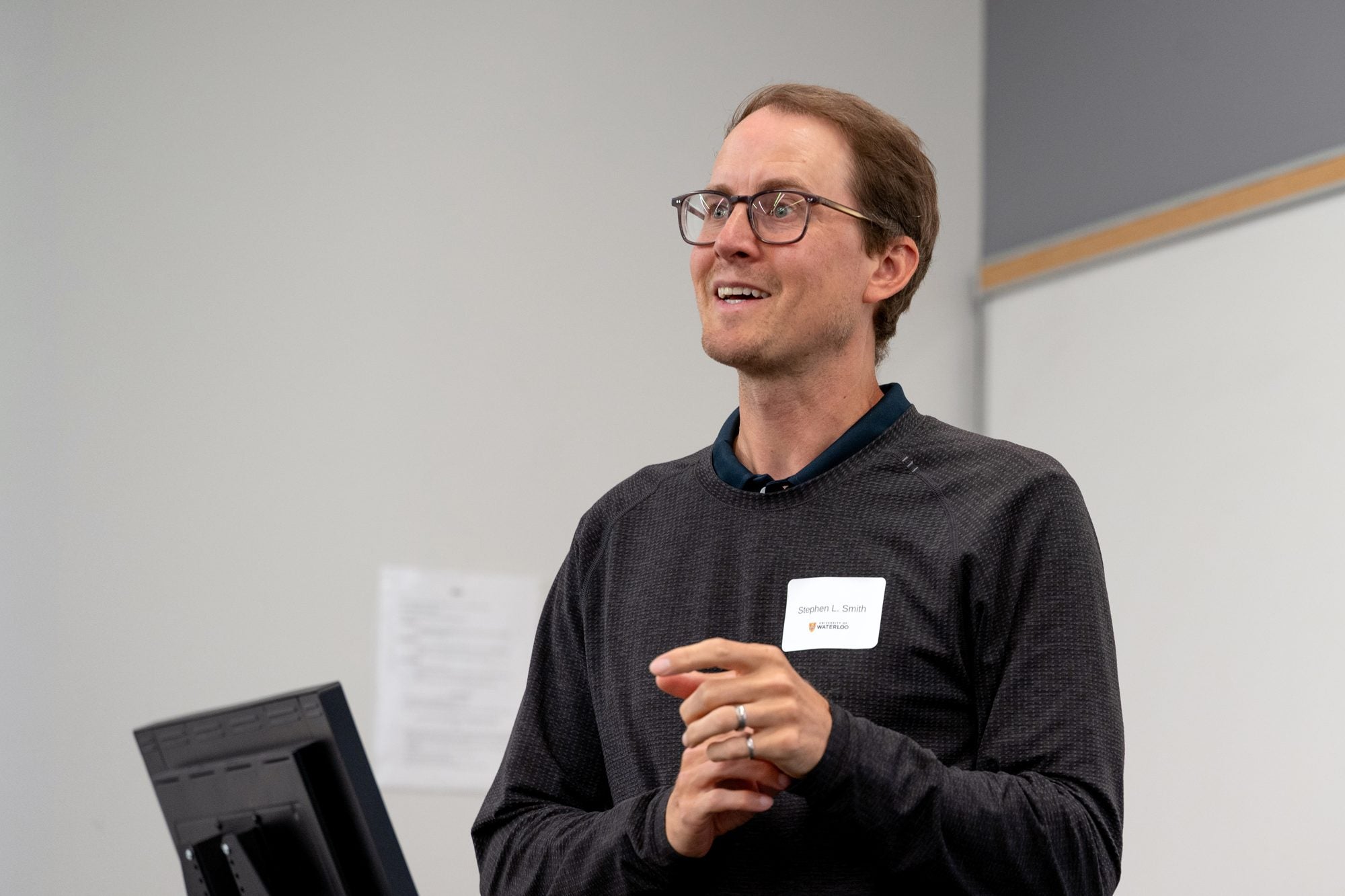 A speaker smiles while presenting during the TD Layer 6 visit