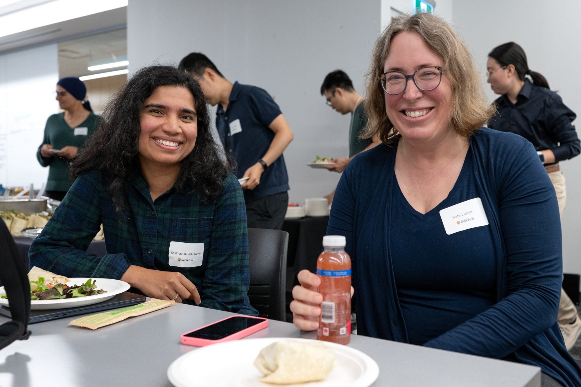 Two attendees smile at a table during lunch