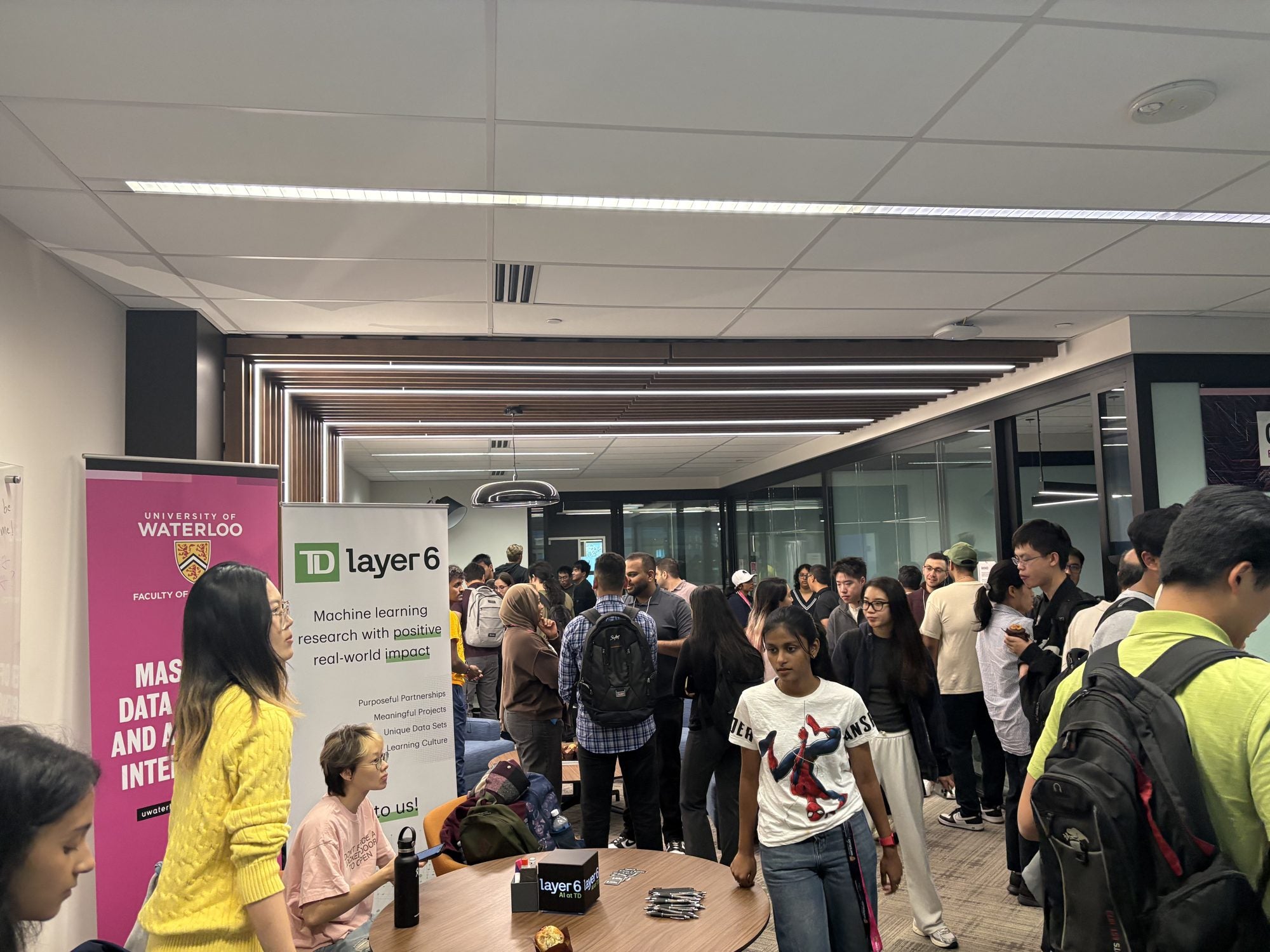 A crowd of students gathers to meet the TD Layer 6 team during the coffee hour
