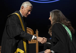 Jennifer Roy shakes hands with chancellor Dominc Barton