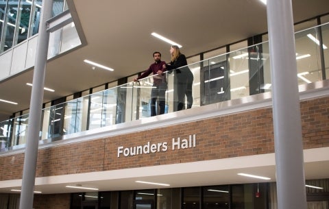 students stand on balcony of Founders Hall