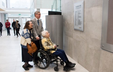 elderly people looking at plaque on wall