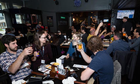 people raise glasses in pub
