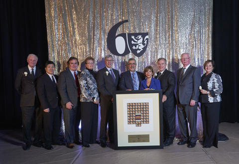 group on stage with 60th anniversary logo