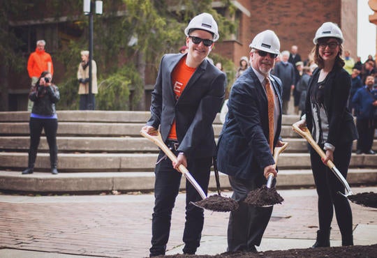 three people with hardhats and shovels at groundbreaking