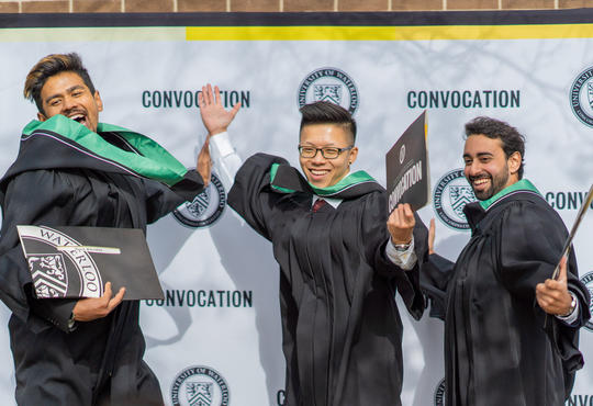 The graduates show off their diplomas