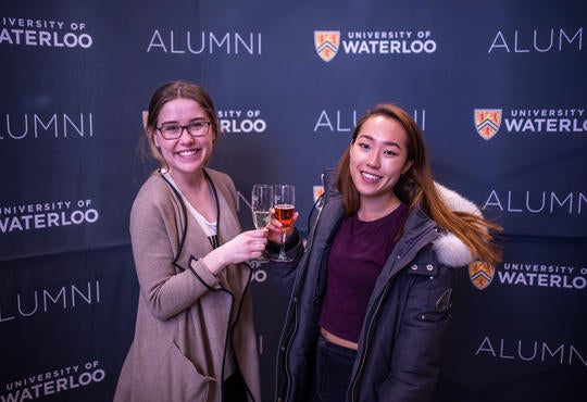 two young women graduates with champagne glasses